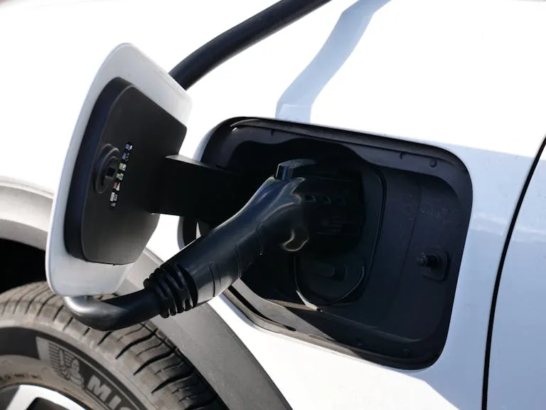 Close-up view of an electric vehicle charging with a focus on the connector and charging port.